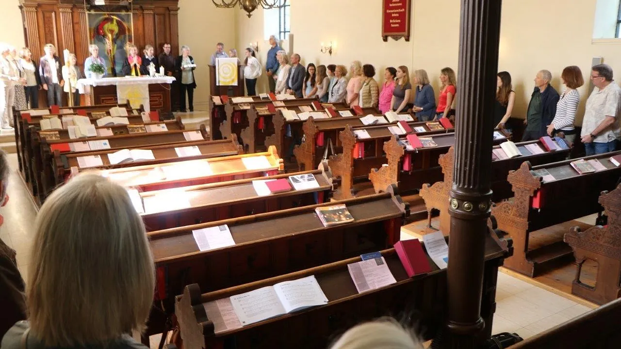 Menschen stehen im Kreis in einer Kirche