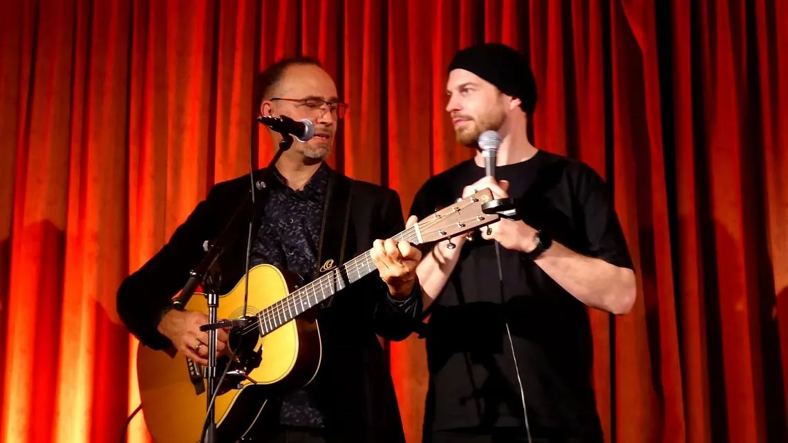 Zwei Musiker auf der Bühne schauen sich an